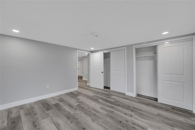 6914 Harbor Dr, Hudson, FL 34667 - unfurnished bedroom featuring two closets, recessed lighting, baseboards, and wood finished floors