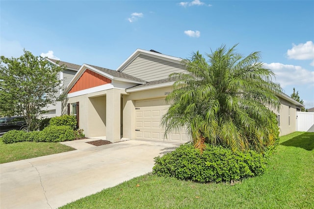 view of front of home featuring an attached garage, concrete driveway, a front yard, and roof with shingles