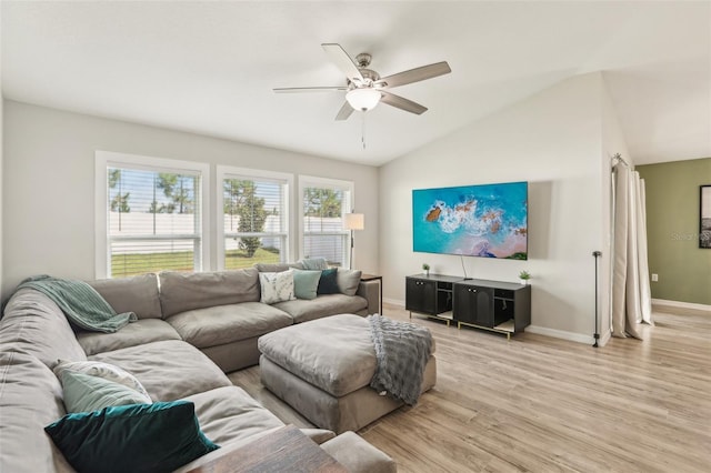 living area featuring a ceiling fan, light wood-style floors, baseboards, and vaulted ceiling