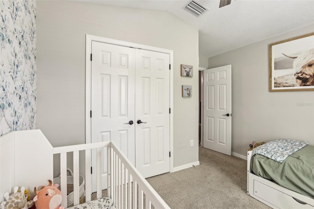 bedroom featuring carpet floors, a closet, baseboards, and vaulted ceiling