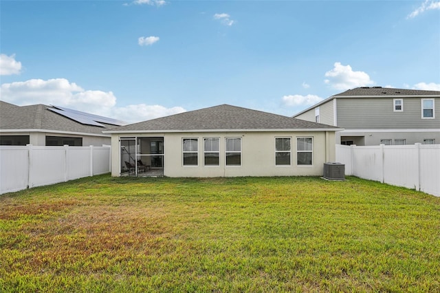 back of house featuring stucco siding, roof with shingles, a sunroom, and central AC