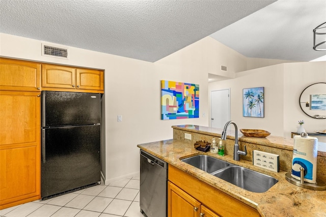 kitchen with freestanding refrigerator, a sink, stainless steel dishwasher, light tile patterned floors, and light stone countertops