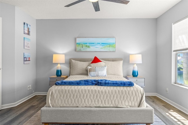 bedroom featuring wood finished floors, baseboards, and a ceiling fan