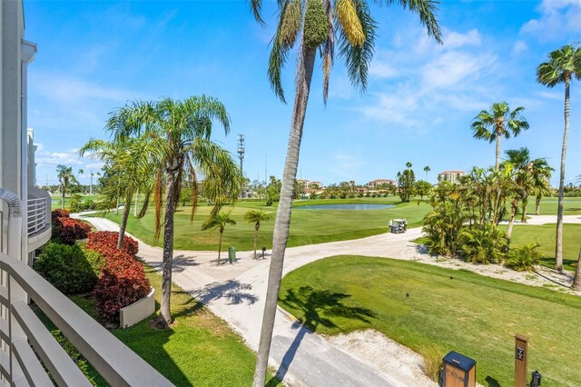 view of home's community featuring golf course view, a water view, and a lawn
