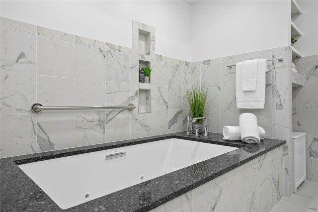 199 Dali Blvd Unit 2, Saint Petersburg, FL 33701 - bathroom featuring tile walls, a jetted tub, and a wainscoted wall