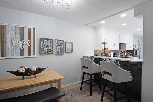 2533 Dolly Bay Dr Unit 203, Palm Harbor, FL 34684 - bar with premium range hood, light wood finished floors, tasteful backsplash, baseboards, and recessed lighting