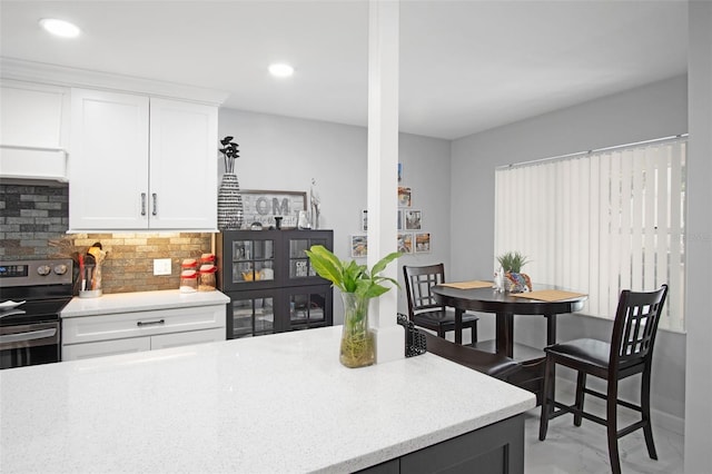 2533 Dolly Bay Dr Unit 203, Palm Harbor, FL 34684 - kitchen featuring decorative backsplash, stainless steel electric range oven, white cabinets, light stone countertops, and recessed lighting