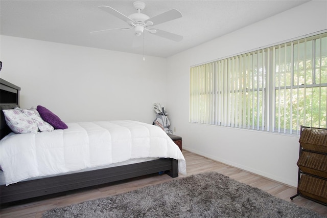 2533 Dolly Bay Dr Unit 203, Palm Harbor, FL 34684 - bedroom featuring multiple windows, baseboards, wood finished floors, and ceiling fan