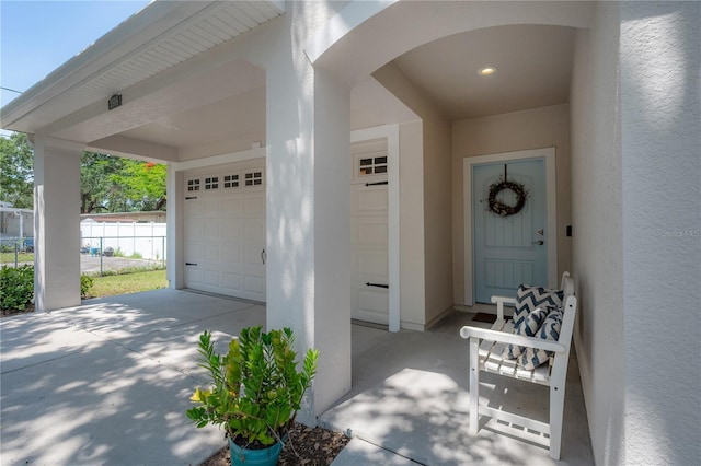 3906 N Lynn Ave, Tampa, FL 33603 - doorway to property featuring stucco siding, a garage, and concrete driveway