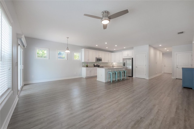 3906 N Lynn Ave, Tampa, FL 33603 - unfurnished living room with baseboards, ceiling fan, light wood-style flooring, and recessed lighting