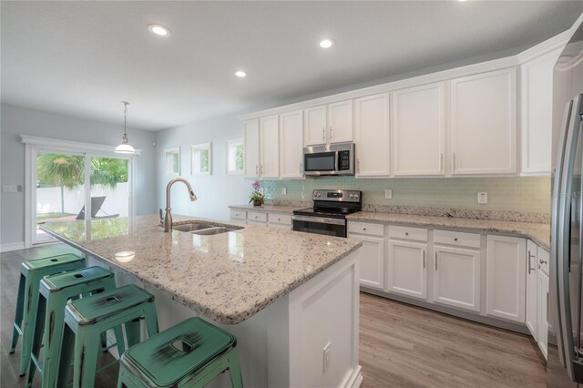 3906 N Lynn Ave, Tampa, FL 33603 - kitchen with appliances with stainless steel finishes, a sink, white cabinetry, backsplash, and recessed lighting