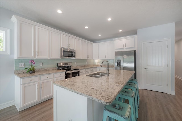 3906 N Lynn Ave, Tampa, FL 33603 - kitchen featuring appliances with stainless steel finishes, a sink, light wood finished floors, white cabinets, and recessed lighting