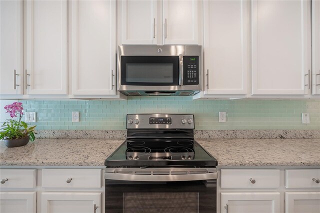 3906 N Lynn Ave, Tampa, FL 33603 - kitchen with stainless steel appliances, white cabinetry, and backsplash