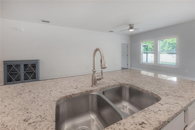 3906 N Lynn Ave, Tampa, FL 33603 - kitchen with a sink, a ceiling fan, and light stone counters