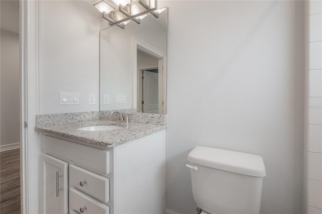 3906 N Lynn Ave, Tampa, FL 33603 - half bath with toilet, vanity, a chandelier, and wood finished floors