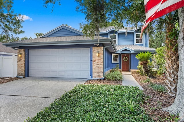 5032 Cypress Trace Dr, Tampa, FL 33624 - view of front facade with driveway, a garage, brick siding, a shingled roof, and fence