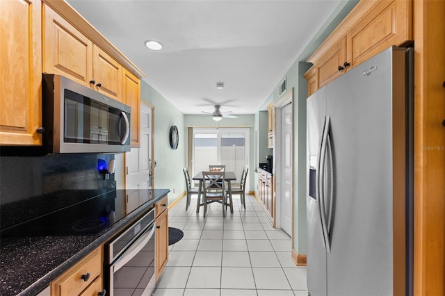 5032 Cypress Trace Dr, Tampa, FL 33624 - kitchen with stainless steel appliances, baseboards, light tile patterned floors, dark stone counters, and ceiling fan
