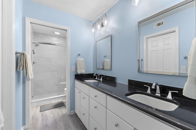 5032 Cypress Trace Dr, Tampa, FL 33624 - bathroom featuring toilet, wood finished floors, a stall shower, and double vanity