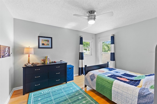 5032 Cypress Trace Dr, Tampa, FL 33624 - bedroom featuring light wood-style floors, a textured ceiling, baseboards, and a ceiling fan