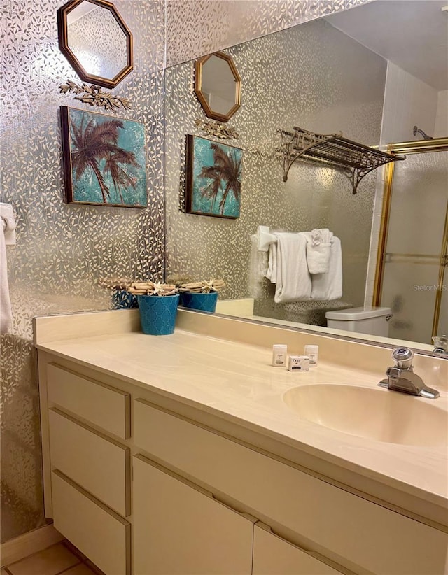 16330 Gulf Blvd Unit 201, Redington Beach, FL 33708 - bathroom featuring toilet, vanity, a shower with door, wallpapered walls, and tile patterned flooring