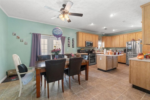 dining space with a textured ceiling, ceiling fan, crown molding, and light tile patterned floors