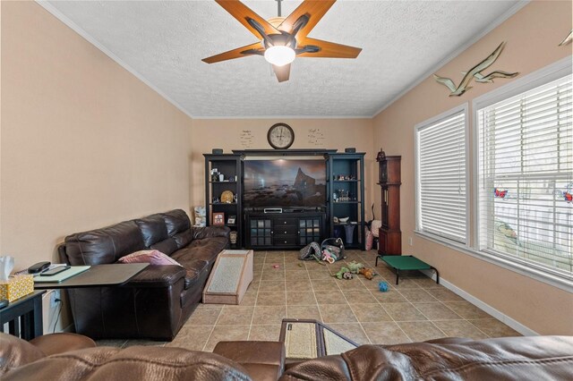 living room featuring a textured ceiling, a ceiling fan, plenty of natural light, tile patterned flooring, and baseboards