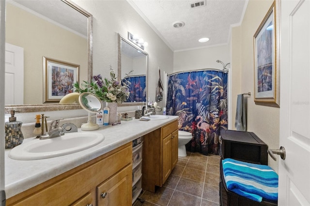 full bathroom featuring tile patterned flooring, toilet, crown molding, double vanity, and a textured ceiling