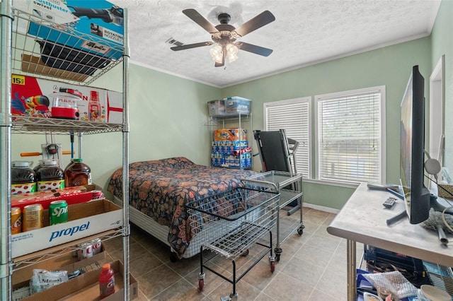 tiled bedroom featuring a textured ceiling, ornamental molding, a ceiling fan, and baseboards