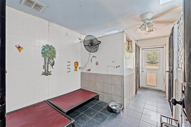 mudroom featuring tile patterned floors, ceiling fan, and tile walls