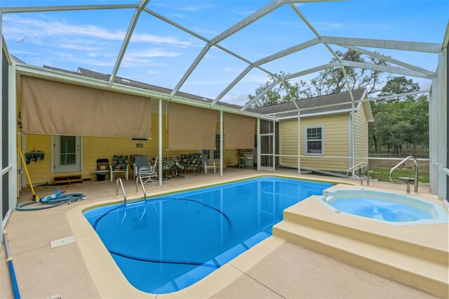 view of pool featuring a patio, a lanai, and a pool with connected hot tub