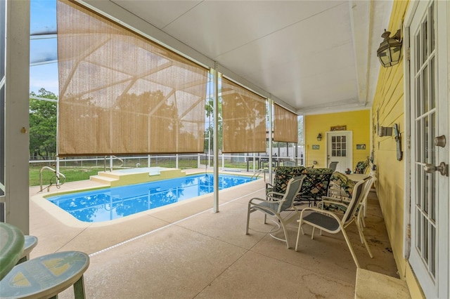 view of swimming pool with glass enclosure and a patio area
