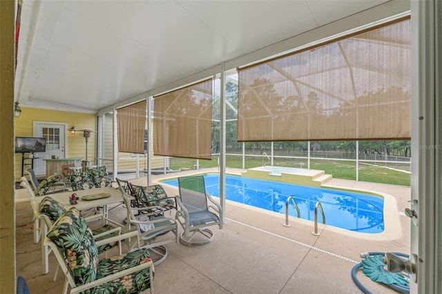 view of swimming pool with a patio, a pool, glass enclosure, and fence