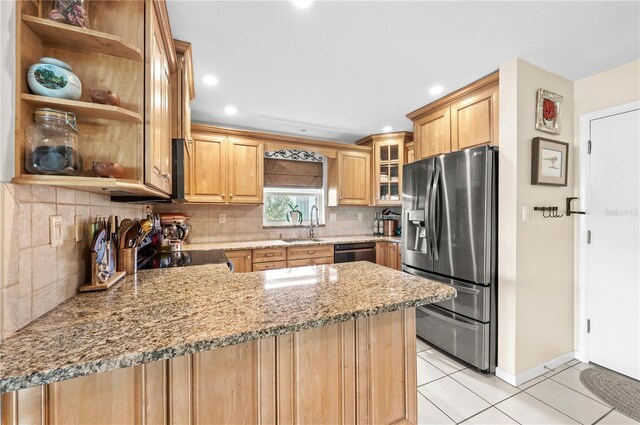 8083 Bayhaven Dr, Seminole, FL 33776 - kitchen featuring stainless steel fridge, light tile patterned floors, black dishwasher, a peninsula, and backsplash