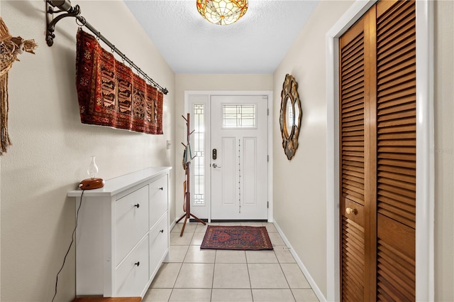 8083 Bayhaven Dr, Seminole, FL 33776 - foyer entrance with light tile patterned floors, a textured ceiling, and baseboards