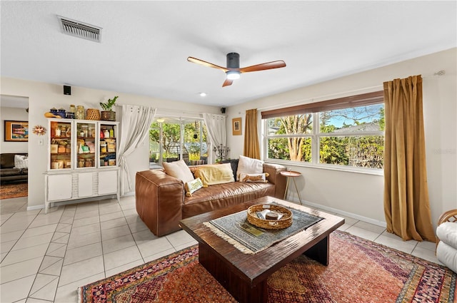 8083 Bayhaven Dr, Seminole, FL 33776 - living area featuring a ceiling fan, healthy amount of natural light, light tile patterned floors, and baseboards