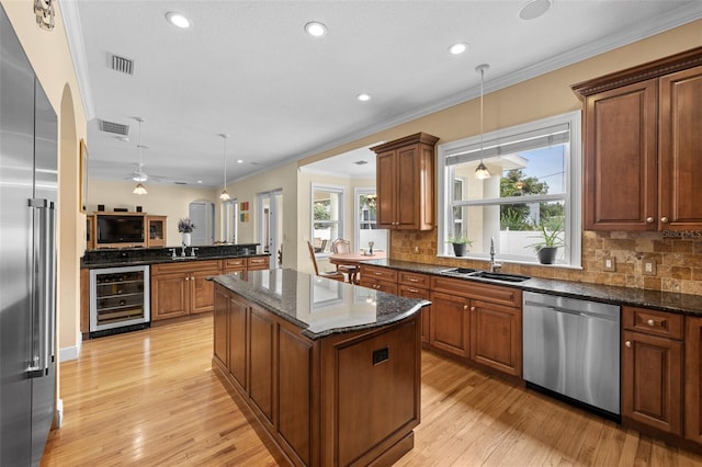 4515 W Leona St, Tampa, FL 33629 - kitchen with stainless steel appliances, beverage cooler, tasteful backsplash, a center island, and ornamental molding