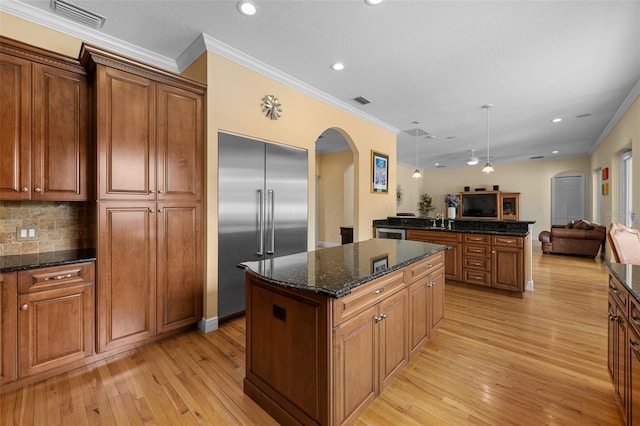 4515 W Leona St, Tampa, FL 33629 - kitchen featuring arched walkways, built in refrigerator, open floor plan, a center island, and light wood-style floors