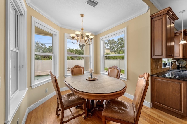 4515 W Leona St, Tampa, FL 33629 - dining room featuring a chandelier, light wood finished floors, and crown molding