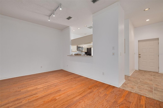 3044 Red Oak Ct Unit 204, Palm Harbor, FL 34684 - empty room with light wood-style flooring, track lighting, recessed lighting, and baseboards