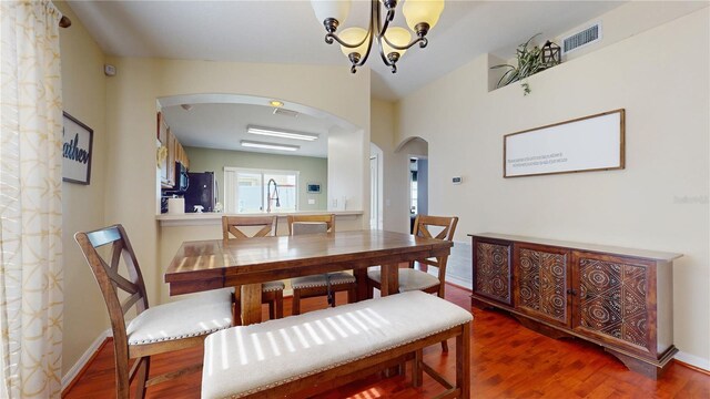 10739 Shady Preserve Dr, Riverview, FL 33579 - dining room with arched walkways, wood finished floors, and a chandelier