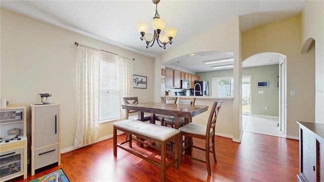 10739 Shady Preserve Dr, Riverview, FL 33579 - dining area featuring arched walkways, a chandelier, and wood finished floors