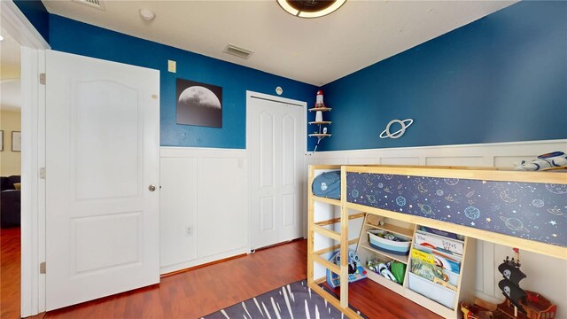 10739 Shady Preserve Dr, Riverview, FL 33579 - bedroom featuring wainscoting, wood finished floors, and a decorative wall