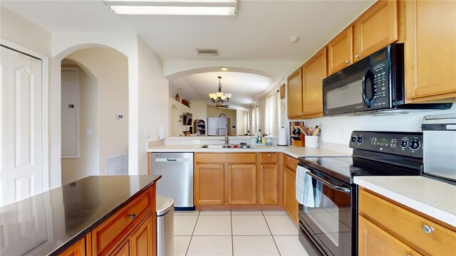 10739 Shady Preserve Dr, Riverview, FL 33579 - kitchen with black appliances, a chandelier, light tile patterned floors, arched walkways, and pendant lighting