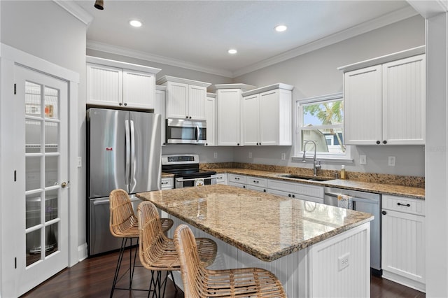 3620 W San Pedro St, Tampa, FL 33629 - kitchen with appliances with stainless steel finishes, a sink, a center island, dark wood-style flooring, and ornamental molding
