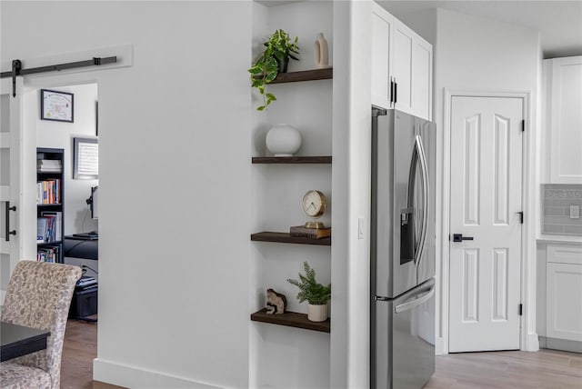 kitchen with open shelves, stainless steel refrigerator with ice dispenser, white cabinets, and light wood-type flooring