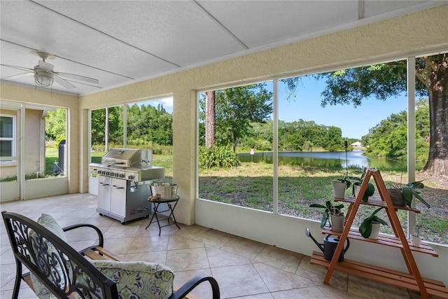 sunroom / solarium with a water view, a ceiling fan, and plenty of natural light