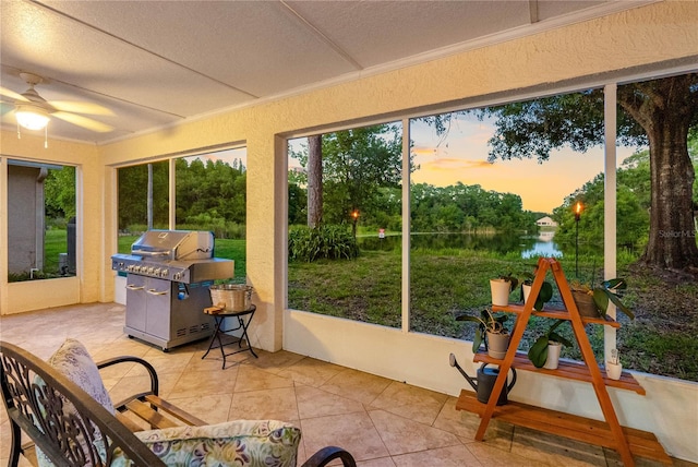 sunroom / solarium featuring ornamental molding, a water view, tile patterned flooring, and a textured ceiling