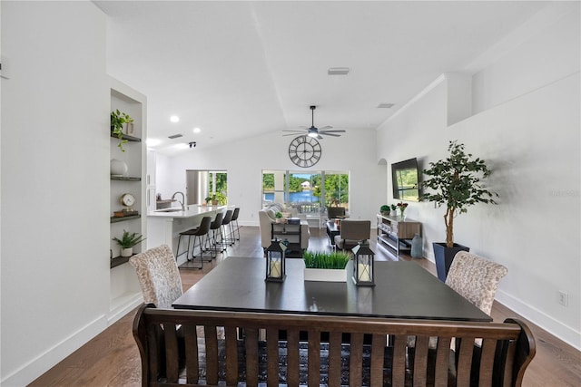 dining room featuring ceiling fan, lofted ceiling, wood finished floors, and baseboards