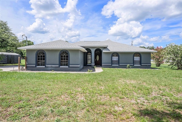 31645 Bugle Ln, Wesley Chapel, FL 33543 - ranch-style house with a front lawn, a shed, and stucco siding