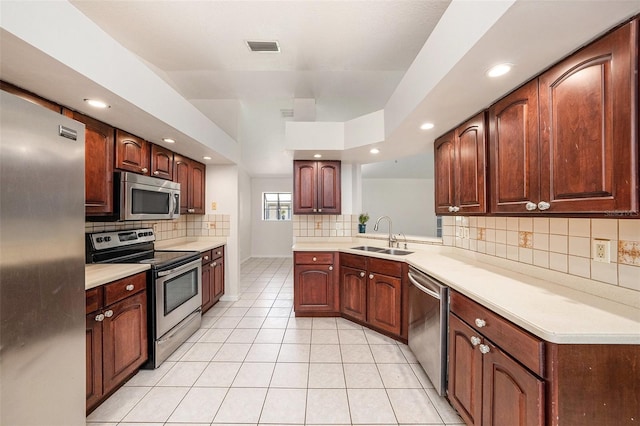 31645 Bugle Ln, Wesley Chapel, FL 33543 - kitchen with stainless steel appliances, backsplash, light tile patterned floors, recessed lighting, and light countertops